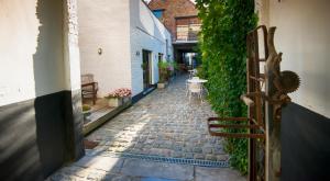 an alley with a cobblestone street with a table and chairs at Gastenkamers UitGaanSlapen in Nieuwpoort