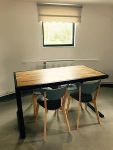 uma mesa de madeira com 2 cadeiras e uma janela em Vila Blanca em Alexandru cel Bun