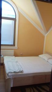 two beds in a room with a window at Guest house Ćane Smestaj in Bela Crkva