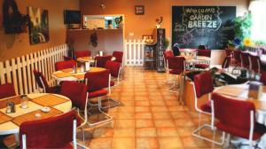 a restaurant with tables and chairs and a chalkboard at Silverwood Inn Hotel Bay Roberts in Bay Roberts