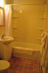 a bathroom with a tub and a sink and a toilet at Silverwood Inn Hotel Bay Roberts in Bay Roberts