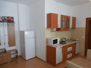uma cozinha com um frigorífico branco e um micro-ondas em Apartament Anatol em Sibiu