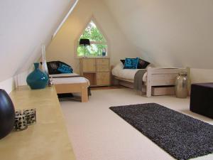ein Wohnzimmer im Dachgeschoss mit einem Bett und einem Fenster in der Unterkunft Bed & Breakfast Kortenhoefsedijk in Kortenhoef