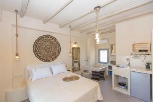a bedroom with a bed and a sink and a tub at Ampelos Suites in Naxos Chora