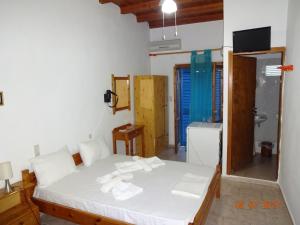 1 dormitorio con cama blanca y baño en Scirocco Rooms en Loutro