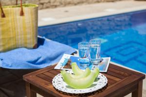 una mesa con una bandeja de fruta y vasos de agua en Ageri Traditional Villa, en Argyroupolis