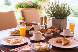 una mesa cubierta con platos de comida y zumo de naranja en Ageri Traditional Villa, en Argyroupolis