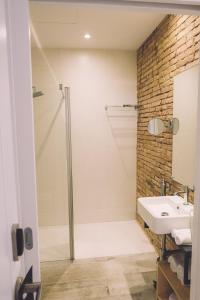 La salle de bains est pourvue d'une douche et d'un lavabo. dans l'établissement Hotelet Casa Padró, à Manresa