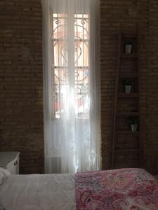 a bedroom with a bed and a window with a ladder at Domus Valencia Apartamentos Loft zona Pechina in Valencia