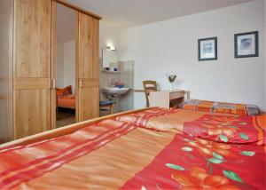 ヴィンターベルクにあるHaus Deimelのベッドルーム1室(大型ベッド1台、カラフルなベッドカバー付)