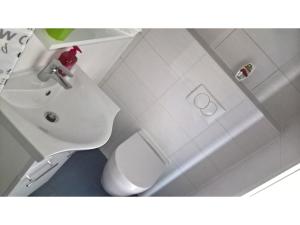 a white bathroom with a toilet and a sink at San Eleuterio Guesthouse in Poreč