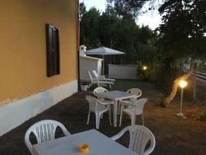 a patio with tables and chairs and an umbrella at Le Case del Parco in Peschici