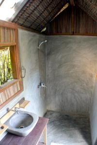 La salle de bains est pourvue d'un lavabo et d'une douche. dans l'établissement Chez Nath, sur l'île Sainte-Marie