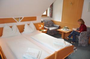 a woman in a hotel room with a large bed at Apartments Bogensperger in Mariapfarr