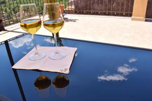 two glasses of white wine sitting on a table at Cento Tari' Guest House in Castiglione di Sicilia