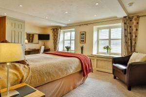 1 dormitorio con cama, escritorio y silla en The Coach House, en Brecon