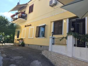 a yellow building with windows and a balcony at Rooms Tusculum in Opatija