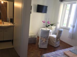 a bathroom with a sink and two chairs in a room at Rooms Tusculum in Opatija