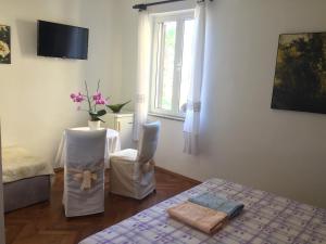 a room with a bed and a table and a window at Rooms Tusculum in Opatija