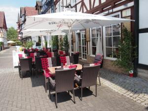 um restaurante com mesas e cadeiras debaixo de um guarda-sol em Hotel Restaurant LR6 em Bad Sooden-Allendorf