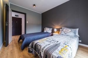 a bedroom with a bed with a blue comforter at Apartament Marina Przy Porcie Nad Niegocinem in Giżycko