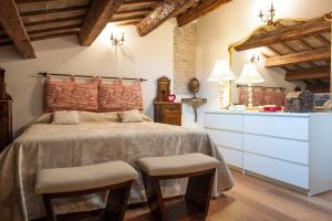 una camera da letto con un letto con due sgabelli di Borgo dei Salinari Apartments a Cervia