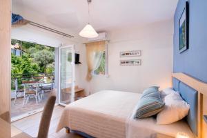 - une chambre avec un lit et un balcon avec une table dans l'établissement Olive Garden Villas and Apartments, à Chrysi Ammoudia