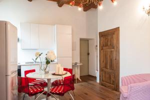 una cucina con tavolo e sedie rosse in una stanza di Borgo dei Salinari Apartments a Cervia
