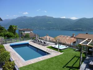 a house with a swimming pool and a view of a lake at Apartments Casa Ghiggi in Brissago
