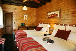 2 camas en una habitación con paredes de madera en Paso del Cóndor en Hipólito Yrigoyen