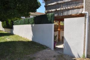 una cerca blanca frente a una casa en Aurillac meuble de tourisme, en Aurillac