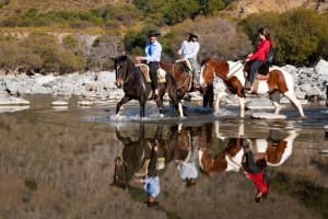 un grupo de personas montando caballos en el agua en Paso del Cóndor en Hipólito Yrigoyen