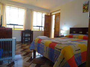 1 dormitorio con 1 cama con una manta colorida en Hospedaje Encanto de Chinchero en Chincheros