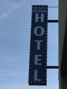 a blue hotel sign hanging from the side of a building at Roxy Hotel in Los Angeles