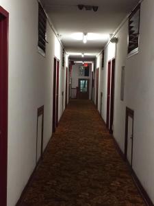 a long hallway with white walls and red doors at Roxy Hotel in Los Angeles