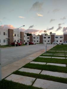 a parking lot with some grass and buildings at Casa Jardines del Sur 3 in Cancún