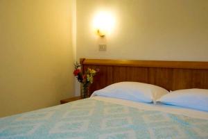 a bedroom with a bed with a vase of flowers at Hotel Viola in Caramanico Terme