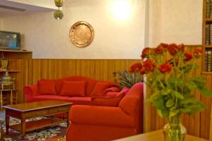 a living room with a red couch and a vase of flowers at Hotel Viola in Caramanico Terme