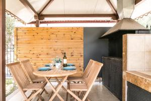 - une table en bois avec des chaises et une bouteille de vin dans l'établissement Olive Tree Apartments, à Fourka