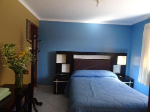 1 dormitorio azul con 1 cama con pared azul en Hospedaje Encanto de Chinchero en Chincheros