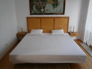 ソゾポルにあるApartment Apolonia 14のベッドルーム1室(白い大型ベッド1台、ナイトスタンド2台付)