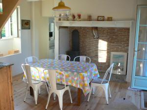 comedor con mesa, sillas y chimenea en La petite maison de Clotilde, en Creysse