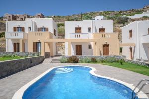 a villa with a swimming pool in front of a house at Naxos Luxury Villas in Mikri Vigla