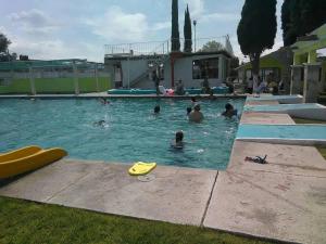 eine Gruppe von Personen, die in einem Schwimmbad schwimmen in der Unterkunft Hotel Cipreses in Ixmiquilpan