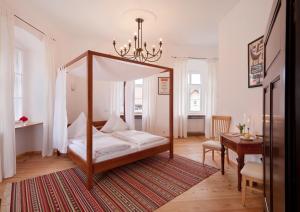 a bedroom with a canopy bed and a table at Schloss Raitenbuch in Kallmünz