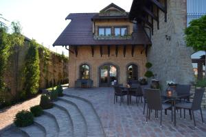 a patio area with chairs and tables and a brick building at Garni Hotel Chicha - Winery ŠKRBIĆ in Belgrade