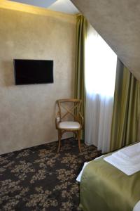 a room with a bed and a chair in it at Garni Hotel Chicha - Winery ŠKRBIĆ in Belgrade