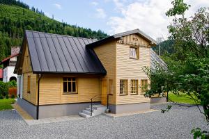シュチルクにあるApartamenty Chabrów 4の黒屋根の小さな木造家屋
