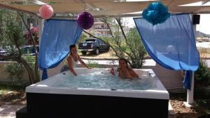 two women in a hot tub under a tent at Hotel Almira in Agia Triada