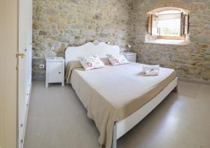 una camera da letto con un letto bianco con due cuscini sopra di Monnalisa a Castiglione di Garfagnana